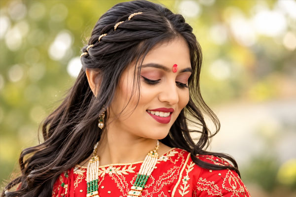 Elegant braided bridal hair updo with pearl floral accessories